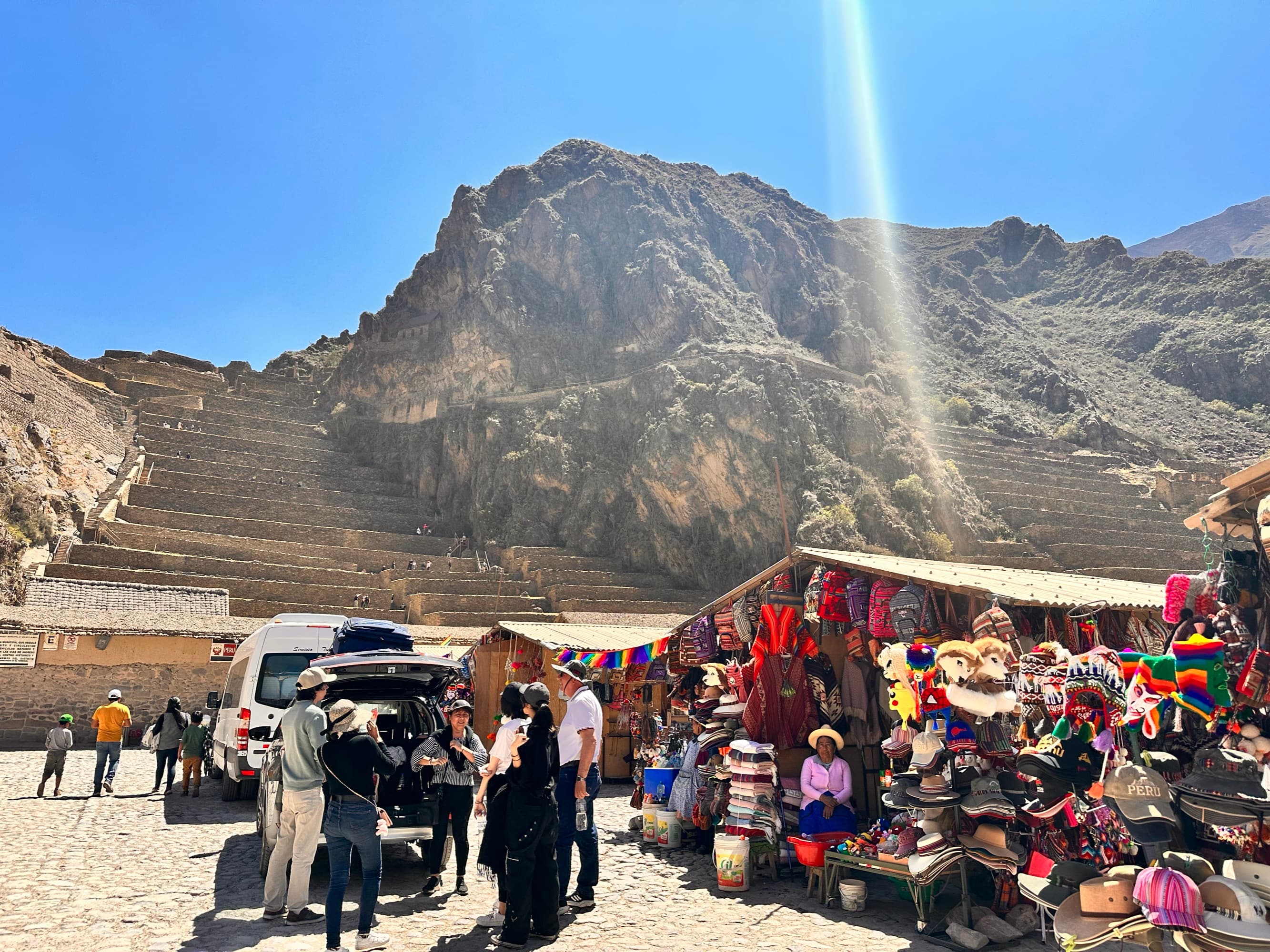 Vista de Ollantaytambo en el Valle Sagrado: terrazas incas, mercado andino y una van turística